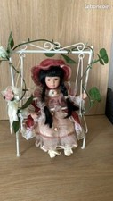 Poupée de collection en porcelaine sur balancelle