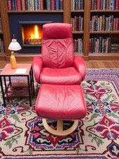fauteuil relax en cuir rouge avec son repose pieds petites alterations sur les b