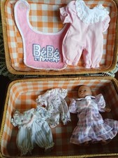 petite poupée dans une malette lavec habits de rechange