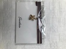 bracelet tissu de grande marque ""avec pampille  .""