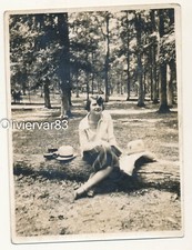 Vintage photo - pretty young woman sitting on tree trunk in woods
