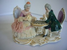 142 -- PORCELAINE ALLEMANDE STATUETTE  COUPLE  ASSIS DEVANT UNE TABLE DE JEUX 