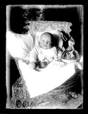 T054 Gros bébé dans un couffin. Poupée, 1900. Photo verre négative. 