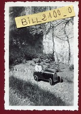 photo ancienne . enfant dans sa voiture à pédales ancienne . 1935