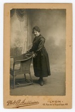 PHOTO CABINET Cie Américaine à Lyon, une femme en noir en studio fauteuil osier