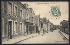 CPA Beaumont-le-Roger, Rue St-Nicolas avec des passants et des bâtiments aligné 