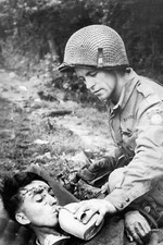 WW2 - Un para américain donne à boire à un blessé allemand