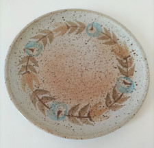 Assiette plate en grès émaillé moucheté.