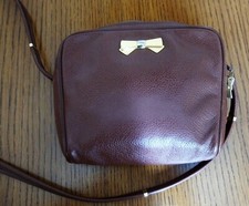 Sac pochette NINA RICCI en cuir grainé camel.