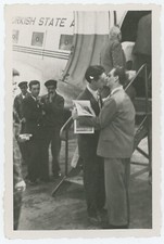 Deux hommes s'embrassent devant un avion. Gay interest.