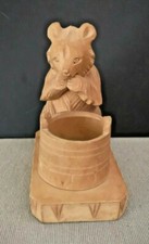 Ours en bois devant un seau