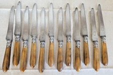 Serie de 12 couteaux de table XIXe, manche corne, virole rocaille métal argenté