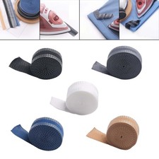 Fer à repasser sur les pantalons de ruban adhésif raccourcissant le rouleau