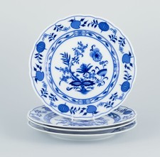 Lot de quatre assiettes à dîner en porcelaine à décor de motifs d'oignon bleu.