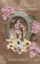 CP BONNE ANNEE PETITE FILLE ASSISE AVEC FLEURS A TRAVERS FER A CHEVAL