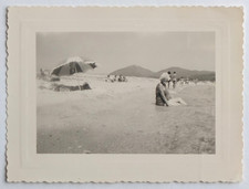 Femme agée assise sable dans