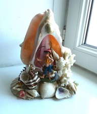 Souvenir de bord de mer sculpture en coquillage avec un pêcheur, kitsch.