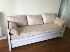 Joli canapé avec motifs formant Lit gigogne en hêtre blanc .