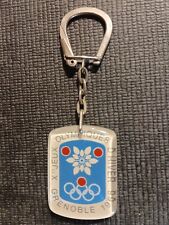 PORTE CLE Jeux Olympiques GRENOBLE 68 en plastique et couleurs du Logo officiel.