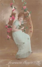 CP HEUREUSE ANNEE FEMME ELEGANTE ASSISE SUR BALANCOIRE FER A CHEVAL ROSES