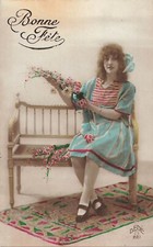 CP BONNE FETE FEMME ASSISE SUR BANC AVEC FLEURS TAPIS - 44397