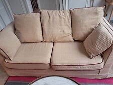 Deux canapés  2 places  tissu à dominante beige, passepoil galon rouge 
