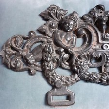 Fronton de porte en fonte illustré de deux putti, feuillages et guirlandes