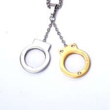 pendentif acier argenté et doré menotte 