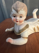 Bébé en biscuit peint couché , souriant Dim Lg 14.5*H9cm