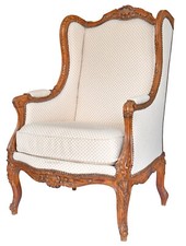 Fauteuil bergère à oreilles de style Louis XV en bois richement sculpté