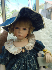 POUPEE EN PORCELAINE  EDW DES POUPEES CARINE  DE 48 CM ASSISE NUMEROTEE 86/2900