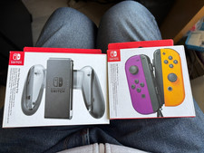 Nintendo Joy-Con Paire de Manettes - Violet Néon/Orange Néon et grip chargeur
