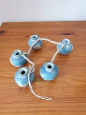 5 petites poteries reliées à