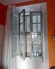 Anciennes fenêtres avec persiennes ou volets d'intérieurs.
