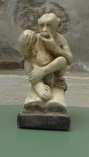 Sculpture en platre. Singe assis sur un Livre de Darwin