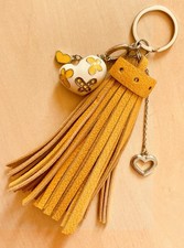 Bijou de sac, pompon en cuir grainé ocre et charms coeurs