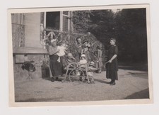 Photo ancienne ?️ Enfants jouent dans charrette à bras en jardin ombragé