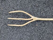 Une fourche à foin trois dents en bois brut ancienne
