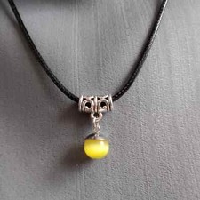 Pendentif avec sa perle en oeil de chat jaune sur cordon ciré noir