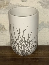 Vase en céramique, fond blanc, décoré de brindilles de bois