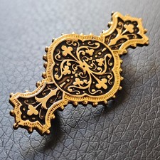 Broche Tolède ciselée sur fond noir dans le goût baroque métal doré