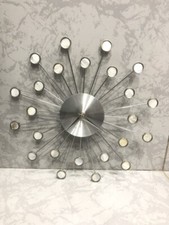 Horloge murale design soleil en métal chrome