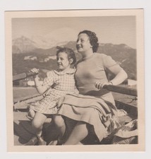 photo ancienne 🎞️ femme et enfant en barque devant montagnes enneigées