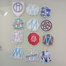 Collection de 12 Stickers OM – L’évolution du blason olympien (5 cm)