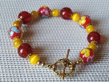 bracelet perles de murano milflori  fond rouge perles de sable rouge p int p or 