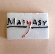 Fève artisanale pub perso MH 2011 - Pâtisserie Matyasy : Plaque de la série