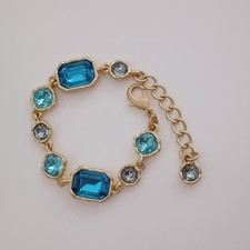 Bracelet plaqué or avec des cristaux bleus. Signé Oscar de la Renta