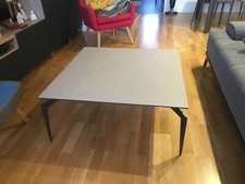 Une table basse carrée "PIXAA". Plateau cérarmique gris, pieds métal anthracite