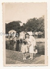 Vintage photo - woman and little girl by a river in a park