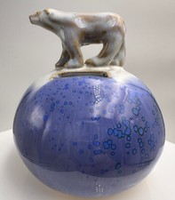 Tirelire en céramique surmontée d'un ours blanc signature à identifier ?